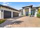 Striking modern home featuring a three-car garage, contemporary design, and beautifully paved driveway at 11506 Harbourside Ln, Parrish, FL 34219