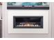 Modern gas fireplace with a white marble surround, a flat-screen television, and custom shelving at 11506 Harbourside Ln, Parrish, FL 34219