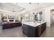 Open-concept kitchen with island, connecting to the living room with fireplace and built-in shelving at 11506 Harbourside Ln, Parrish, FL 34219