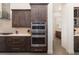 Modern kitchen features stainless steel appliances, dark cabinets and modern backsplash at 11506 Harbourside Ln, Parrish, FL 34219