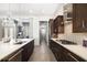Open kitchen boasts dark wood cabinets, stainless steel appliances, and modern lighting at 11506 Harbourside Ln, Parrish, FL 34219