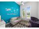 Charming living room featuring a colorful area rug, blue accent wall, and coastal decorations at 11506 Harbourside Ln, Parrish, FL 34219