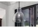 Close-up of a modern clear glass pendant light fixture with a black rod and visible bulb at 11506 Harbourside Ln, Parrish, FL 34219