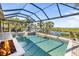 Beautiful screened-in pool area overlooking a waterway, perfect for relaxation and outdoor enjoyment with a fire pit at 11506 Harbourside Ln, Parrish, FL 34219