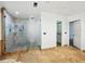 Walk-in shower with stone tile, glass doors, recessed lighting and neutral color palette in renovated bath at 13004 Bell Creek Chase, Riverview, FL 33569