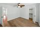 Bright bedroom features light hardwood floors, ceiling fan, closet, and doorway to another room at 13004 Bell Creek Chase, Riverview, FL 33569