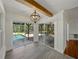 Sunlit dining area leads to a screened-in pool and backyard, featuring tiled floors and modern lighting fixture at 13004 Bell Creek Chase, Riverview, FL 33569