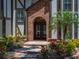 Close up of home's brick entryway, featuring a decorative door, beautiful landscaping, and lush trees at 13004 Bell Creek Chase, Riverview, FL 33569