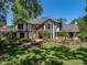 Charming Tudor-style home featuring a brick entrance, lush landscaping, and well-manicured lawn at 13004 Bell Creek Chase, Riverview, FL 33569