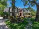 Charming Tudor-style home featuring a brick entrance, lush landscaping, and mature trees at 13004 Bell Creek Chase, Riverview, FL 33569