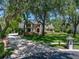 Charming Tudor-style home featuring a brick entrance, lush landscaping, and long driveway at 13004 Bell Creek Chase, Riverview, FL 33569
