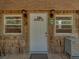 Inviting front entrance with a white door framed by windows, sconces and wood shingle siding at 13004 Bell Creek Chase, Riverview, FL 33569