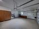 Attached garage with custom cabinets, epoxy floors, bright lighting and storage racks overhead at 13004 Bell Creek Chase, Riverview, FL 33569