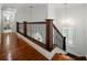 Upstairs hallway with hardwood floors, decorative iron railing and pendant lighting leading to bedrooms at 13004 Bell Creek Chase, Riverview, FL 33569