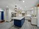 Bright kitchen features a center island with a white countertop, contrasting blue cabinetry, and pendant lighting at 13004 Bell Creek Chase, Riverview, FL 33569