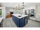 Open kitchen boasts an island with sink, stainless steel appliances, and transitions into a living room with a fireplace at 13004 Bell Creek Chase, Riverview, FL 33569