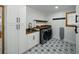 Laundry room featuring stylish patterned floors, modern washer/dryer, and ample cabinet space at 13004 Bell Creek Chase, Riverview, FL 33569