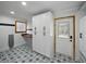 Functional laundry room with patterned tile flooring, built-in storage cabinets, and a window at 13004 Bell Creek Chase, Riverview, FL 33569