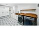 Bright laundry room features modern washer and dryer, butcher block countertop and custom shelving for convenient storage at 13004 Bell Creek Chase, Riverview, FL 33569