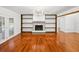 A bright living room with hardwood floors, a cozy fireplace, built-in shelving and access to the backyard at 13004 Bell Creek Chase, Riverview, FL 33569