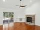 Cozy living room with a brick fireplace, hardwood floors, and sliding glass doors to the outdoor patio at 13004 Bell Creek Chase, Riverview, FL 33569