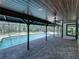 View of the pool and hot tub from the brick patio under the covered deck with wooden ceiling at 13004 Bell Creek Chase, Riverview, FL 33569