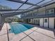 Gorgeous in-ground swimming pool enclosed by a screen and surrounded by a brick patio, overlooked by a second story at 13004 Bell Creek Chase, Riverview, FL 33569