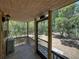 Cozy porch overlooking a lush green landscape, screened door and rustic wooden railing at 13004 Bell Creek Chase, Riverview, FL 33569