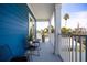 Spacious blue-accented balcony with multiple seating, offering a relaxing outdoor space with palm tree views at 13117 4Th E St, Madeira Beach, FL 33708