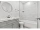 Bright bathroom with a grey vanity, white marble-esque tile shower, and classic fixtures at 13117 4Th E St, Madeira Beach, FL 33708