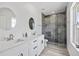 Sleek bathroom with double vanity, quartz countertop, and a glass-enclosed tiled shower at 13117 4Th E St, Madeira Beach, FL 33708