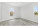 Bright bedroom with hardwood floors, two windows with natural light, and a ceiling fan at 13117 4Th E St, Madeira Beach, FL 33708