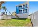A three story coastal home with double balconies, a lush lawn, and a storage shed at 13117 4Th E St, Madeira Beach, FL 33708