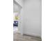 Hallway leads to an open concept living area with light colored wood floors, base trim, and white walls at 13117 4Th E St, Madeira Beach, FL 33708