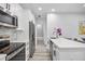 Well-lit kitchen with stainless steel appliances, quartz countertops, and an adjoining space for relaxing and dining at 13117 4Th E St, Madeira Beach, FL 33708