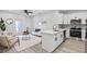 Open-concept space with sleek white kitchen featuring stainless appliances seamlessly connected to a stylish living area at 13117 4Th E St, Madeira Beach, FL 33708