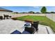 A patio with lounge seating and a grill overlooks a large backyard with a privacy fence at 15718 Fort Island Pl, Sun City Center, FL 33573
