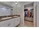 Bathroom with double vanity and an open walk-in closet space at 15718 Fort Island Pl, Sun City Center, FL 33573
