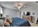 This bedroom features a comfortable blue quilted bedspread, modern wood media cabinet, and bright natural light at 15718 Fort Island Pl, Sun City Center, FL 33573