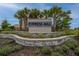Cypress Mill neighborhood entrance sign surrounded by palm trees and professionally landscaped garden at 15718 Fort Island Pl, Sun City Center, FL 33573