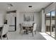 Dining area with a round table, chairs, modern light fixture, and sliding glass doors for natural light at 15718 Fort Island Pl, Sun City Center, FL 33573