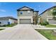 Two-story home with a two-car garage and a well-manicured lawn and landscaped garden at 15718 Fort Island Pl, Sun City Center, FL 33573