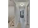 Hallway leading to bedrooms with natural light, gray walls, and white trim at 15718 Fort Island Pl, Sun City Center, FL 33573