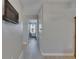 The bright hallway leads to a cozy bedroom, featuring light, airy floors and a sleek, wall-mounted television at 15718 Fort Island Pl, Sun City Center, FL 33573