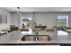 Open kitchen featuring a granite island with a stainless steel sink, overlooking the backyard at 15718 Fort Island Pl, Sun City Center, FL 33573