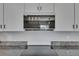 Modern kitchen with white cabinets, granite countertops, and stainless steel microwave at 15718 Fort Island Pl, Sun City Center, FL 33573