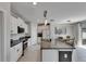 Kitchen area with white cabinets, granite countertops, stainless appliances, and pendant lighting at 15718 Fort Island Pl, Sun City Center, FL 33573