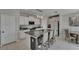 Modern kitchen with granite countertops, white cabinets, and a kitchen island with barstool seating at 15718 Fort Island Pl, Sun City Center, FL 33573