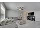 Comfortable living room featuring a plush sectional sofa, ceiling fan, and decorative fireplace at 15718 Fort Island Pl, Sun City Center, FL 33573