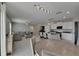 Bright, open-concept living room featuring modern lighting, tile floors, and a comfortable sectional sofa at 15718 Fort Island Pl, Sun City Center, FL 33573